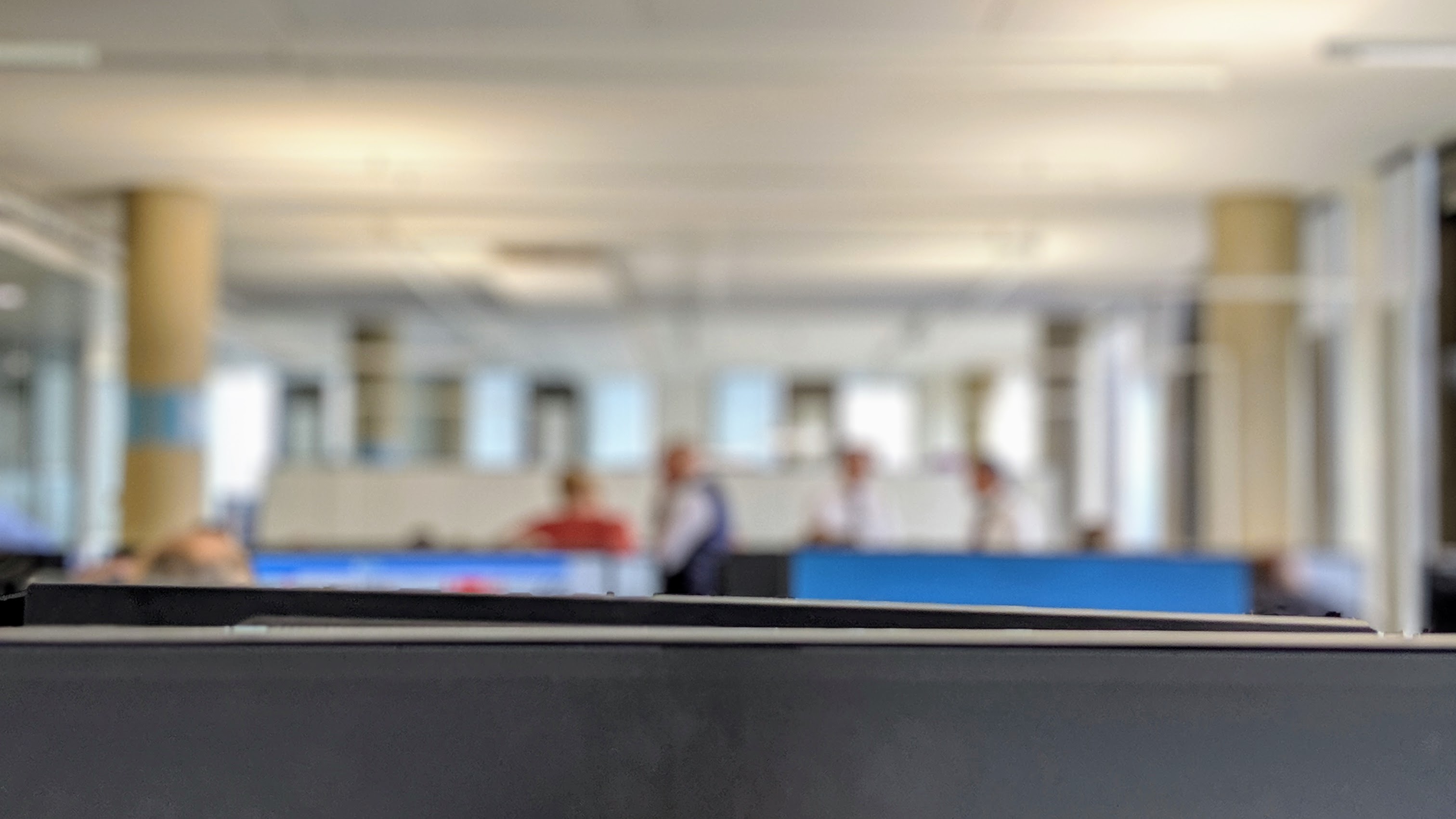 View of the open-plan office with some people in the background standing around